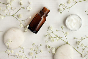 Natural skincare products,white stones and flowers, top view.